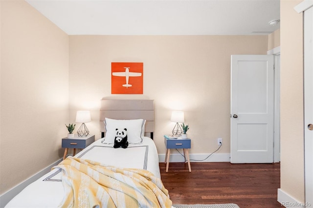 bedroom with baseboards and wood finished floors