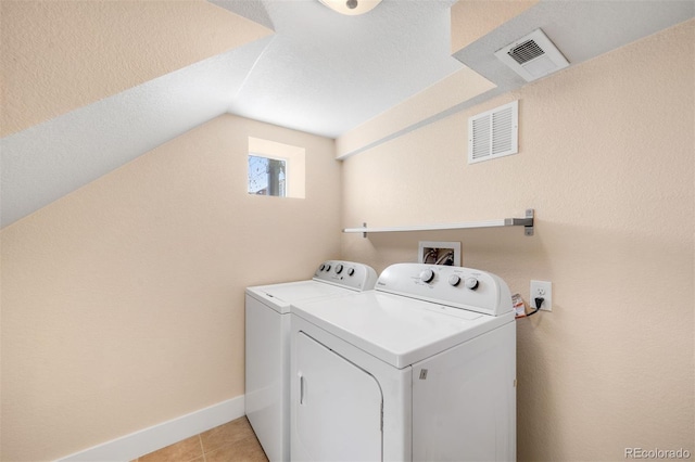 laundry area with visible vents, separate washer and dryer, light tile patterned flooring, and laundry area