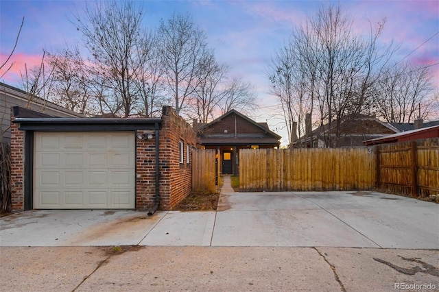 view of front of property featuring a garage, fence, and brick siding