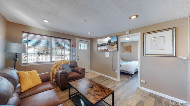 living room featuring light hardwood / wood-style flooring and a textured ceiling