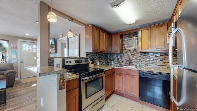 kitchen featuring sink, appliances with stainless steel finishes, backsplash, decorative light fixtures, and kitchen peninsula