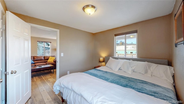 bedroom with multiple windows and light hardwood / wood-style floors