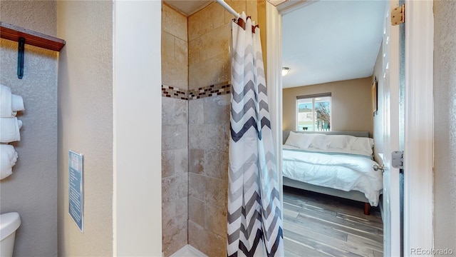 bathroom with wood-type flooring, toilet, and walk in shower