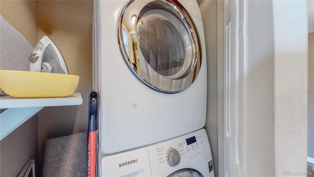 washroom featuring stacked washer / drying machine