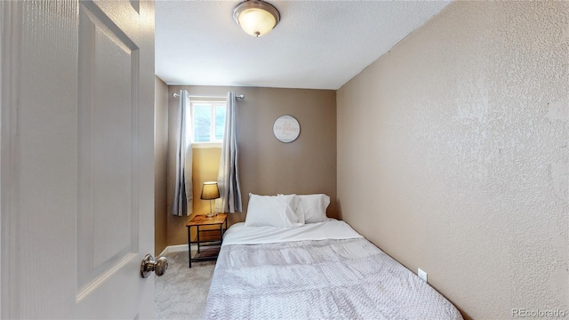 bedroom with light carpet and a textured ceiling