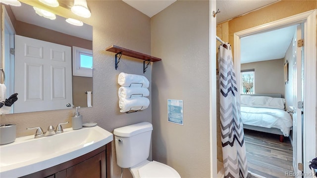 3282 W 66th Ave, Denver, CO 80221 - bathroom with a textured wall, vanity, toilet, healthy amount of natural light, and wood finished floors