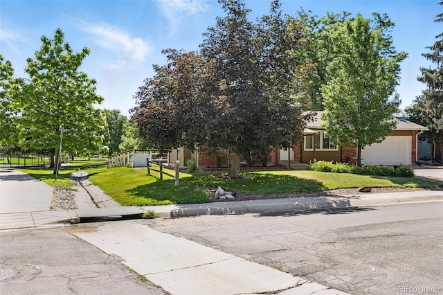 1380 Holly Dr E, Broomfield, CO 80020 - view of property hidden behind natural elements featuring a garage, brick siding, and concrete driveway