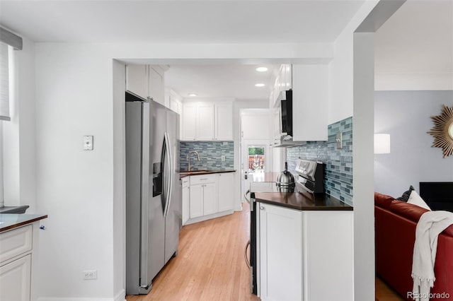 1185 Glencoe St, Denver, CO 80220 - kitchen with appliances with stainless steel finishes, dark countertops, backsplash, white cabinetry, and recessed lighting