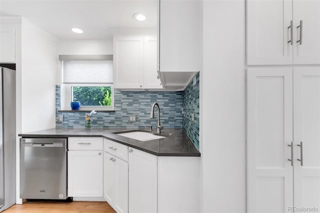 1185 Glencoe St, Denver, CO 80220 - kitchen with stainless steel appliances, dark countertops, white cabinetry, backsplash, and recessed lighting