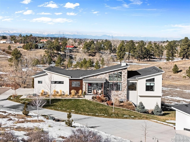 view of front facade featuring a mountain view and a front yard