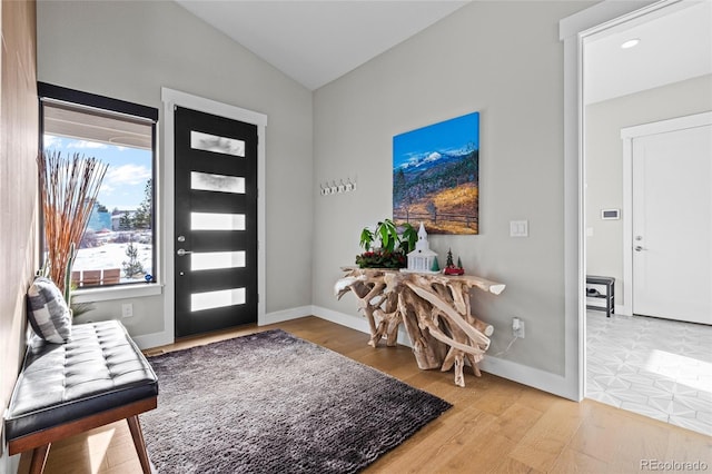 entryway with hardwood / wood-style floors and lofted ceiling