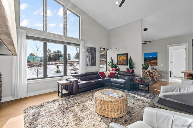 living room with light wood-type flooring, high vaulted ceiling, and ceiling fan