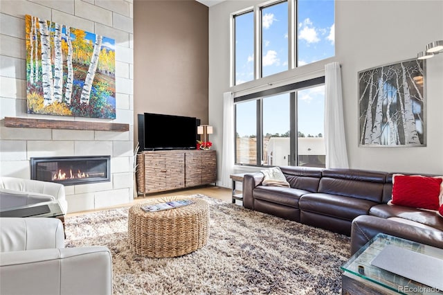 living room with a fireplace and a high ceiling