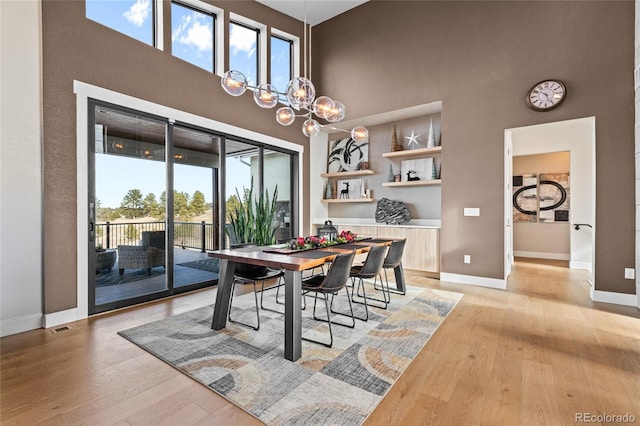 dining space featuring a wealth of natural light, a chandelier, and light wood-type flooring