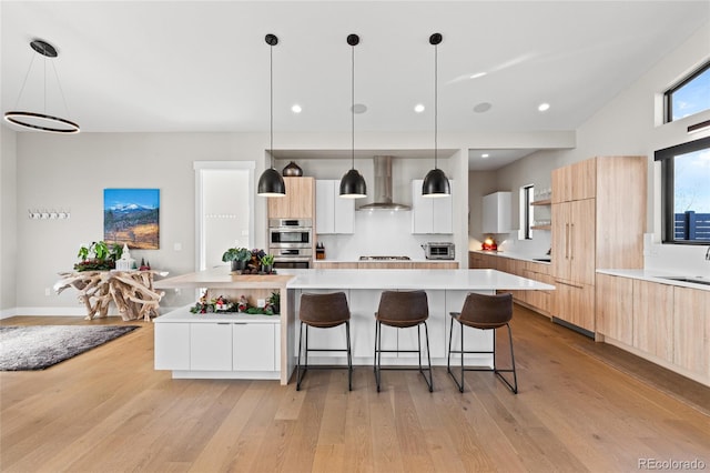 kitchen with white cabinets, decorative backsplash, a kitchen island, and wall chimney exhaust hood