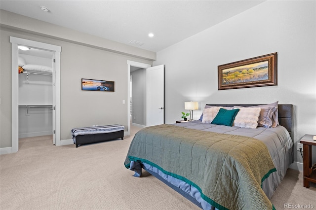 carpeted bedroom with a spacious closet and a closet