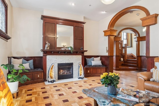 living room featuring recessed lighting, a wainscoted wall, a healthy amount of sunlight, and a fireplace