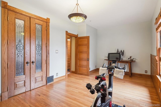 exercise area featuring baseboards, visible vents, french doors, and light wood-type flooring