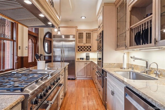 1022 N Pearl St Unit 101, Denver, CO 80203 - kitchen featuring a sink, light wood-style floors, high end appliances, glass insert cabinets, and a warming drawer