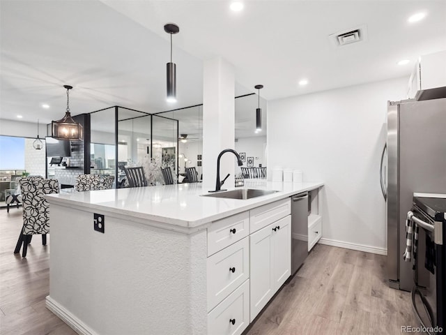 800 N Pearl St Unit 1203, Denver, CO 80203 - kitchen featuring a sink, appliances with stainless steel finishes, light wood-style floors, white cabinets, and recessed lighting