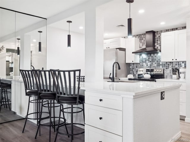 800 N Pearl St Unit 1203, Denver, CO 80203 - kitchen featuring wall chimney range hood, stainless steel range with electric stovetop, freestanding refrigerator, wood finished floors, and recessed lighting