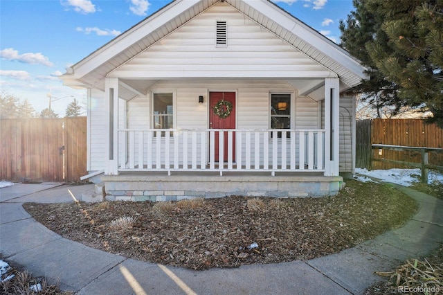 view of front of property featuring covered porch and fence