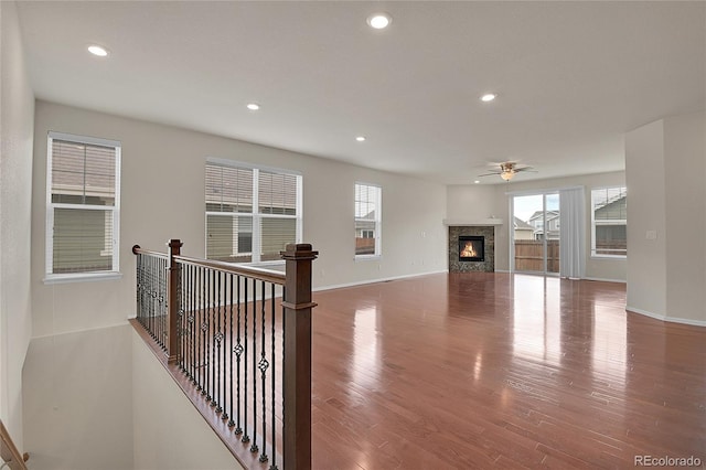 16076 Columbine Pl, Thornton, CO 80602 - unfurnished living room with wood finished floors, recessed lighting, a ceiling fan, a glass covered fireplace, and baseboards