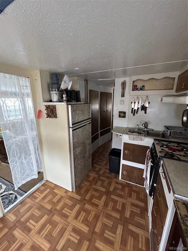 10795 County Road 197a Unit 194, Nathrop, CO 81236 - kitchen featuring a textured ceiling, freestanding refrigerator, gas stove, a sink, and open shelves