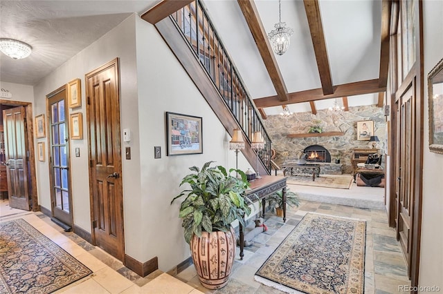 entrance foyer featuring a fireplace, a chandelier, high vaulted ceiling, and beam ceiling