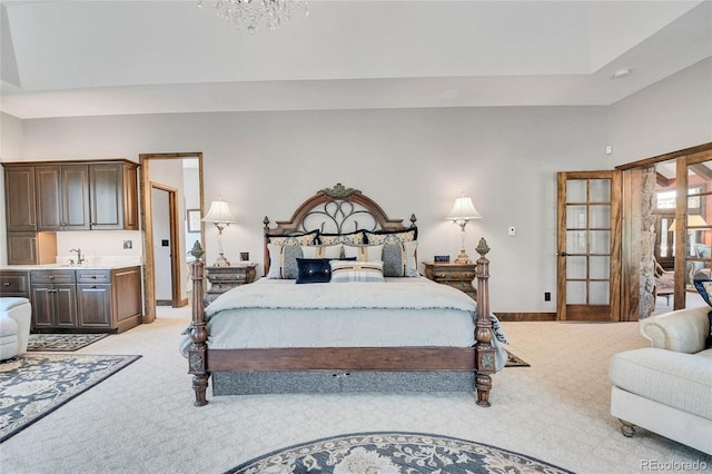 carpeted bedroom featuring sink and an inviting chandelier