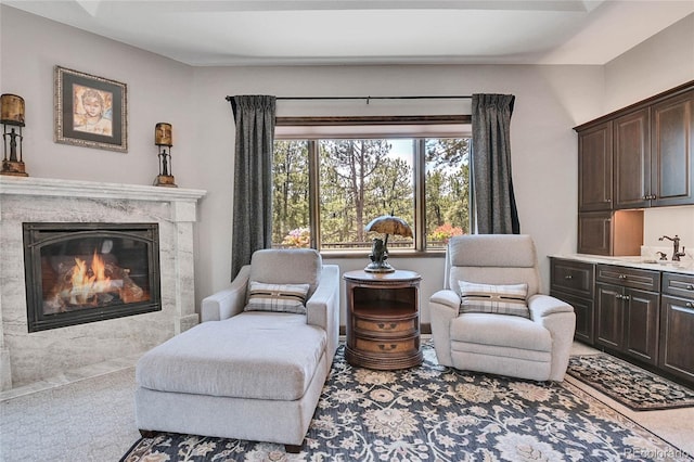 sitting room with a fireplace and sink