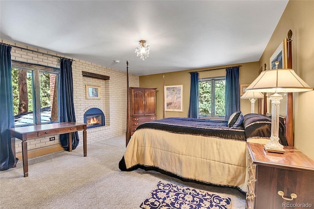 bedroom featuring multiple windows, a fireplace, brick wall, and carpet