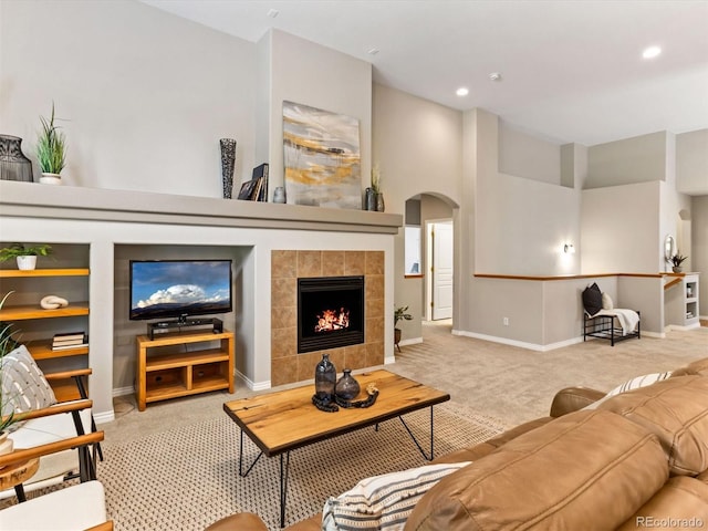 1836 S Kendall Ct, Lakewood, CO 80232 - carpeted living area featuring arched walkways, baseboards, a tiled fireplace, and recessed lighting