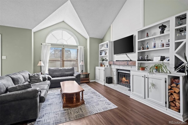 living room featuring dark wood-type flooring, vaulted ceiling, and a textured ceiling