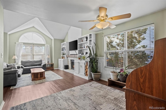 living room with dark hardwood / wood-style flooring, vaulted ceiling, and ceiling fan