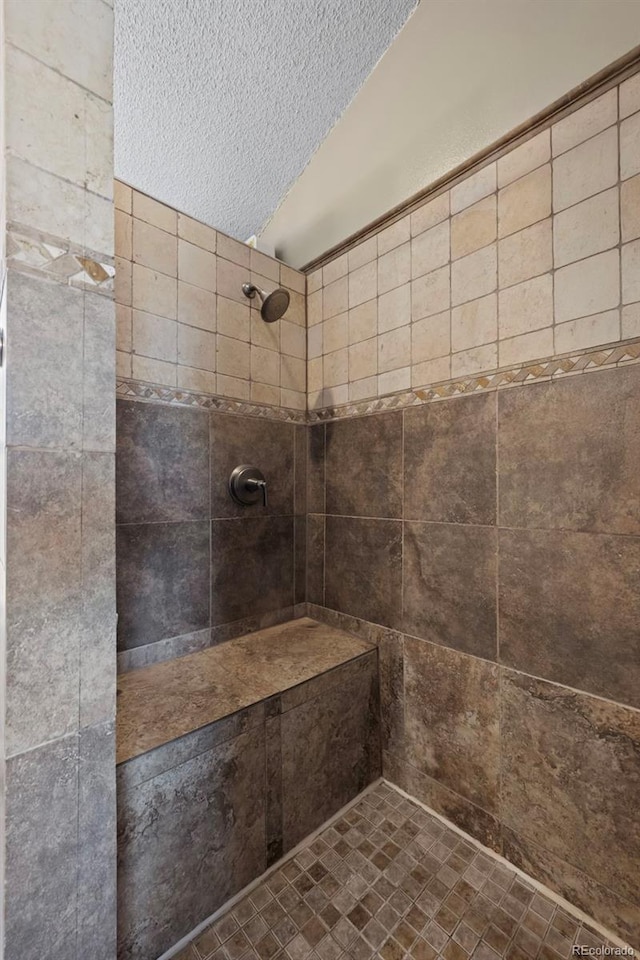 bathroom featuring tiled shower and a textured ceiling