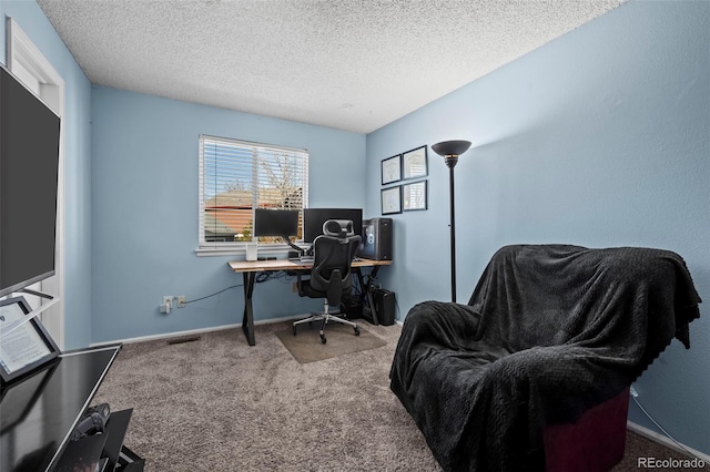 carpeted home office with a textured ceiling