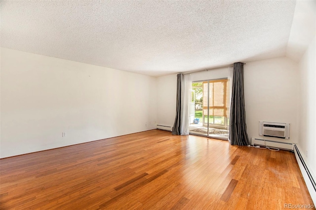 3144 S Wheeling Way Unit 106, Aurora, CO 80014 - empty room with a baseboard radiator, light wood-type flooring, an AC wall unit, and a textured ceiling