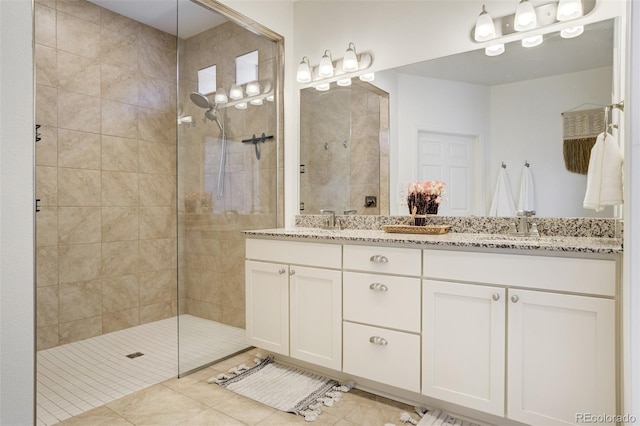 full bathroom with walk in shower, double vanity, and tile patterned floors
