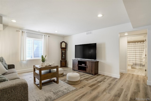 living room with light wood-style floors, baseboards, and recessed lighting