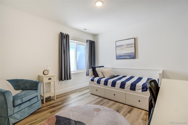 bedroom featuring wood finished floors and baseboards