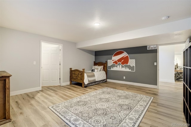 bedroom with light wood finished floors and baseboards