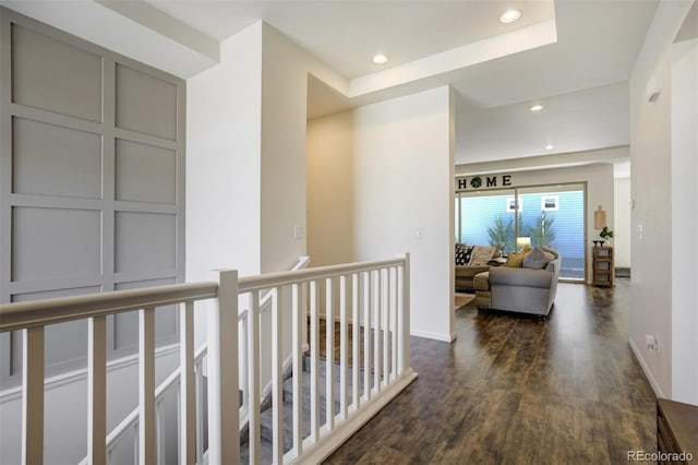 corridor featuring an upstairs landing, dark wood-type flooring, baseboards, and recessed lighting