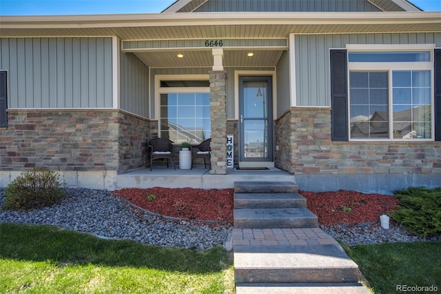 doorway to property with covered porch and stone siding