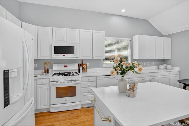 8651 Mallard Pl, Highlands Ranch, CO 80126 - kitchen featuring white appliances, light countertops, vaulted ceiling, white cabinets, and recessed lighting