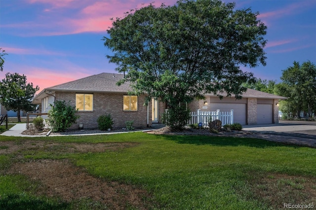 view of front of property with a garage and a yard