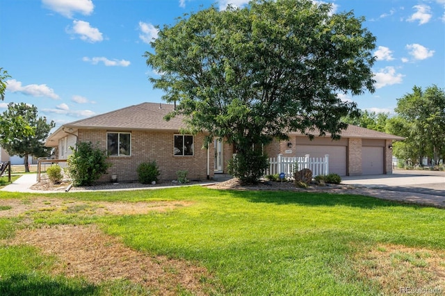 ranch-style house featuring a garage and a front lawn