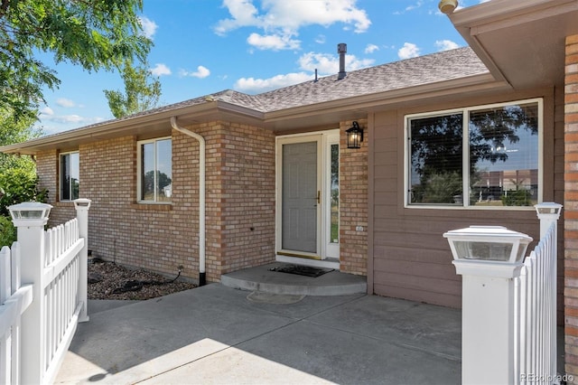 view of exterior entry with a patio area