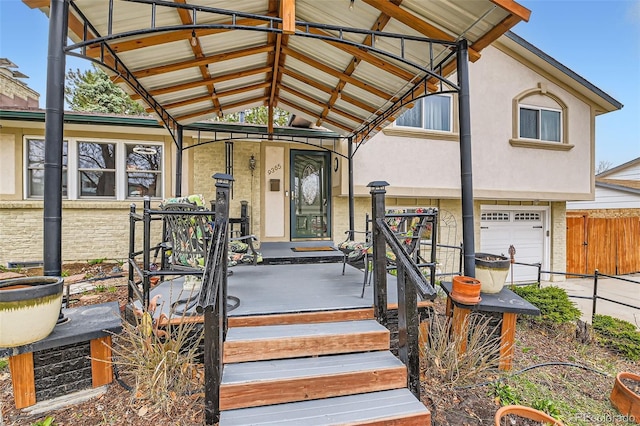 exterior space with a garage, stucco siding, and fence