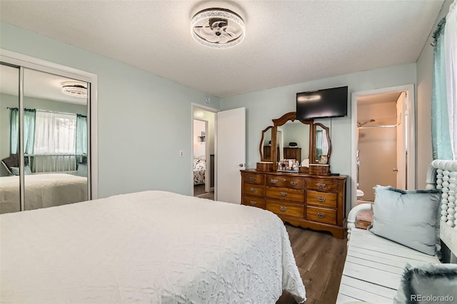 bedroom with ensuite bath, a textured ceiling, a closet, and wood finished floors